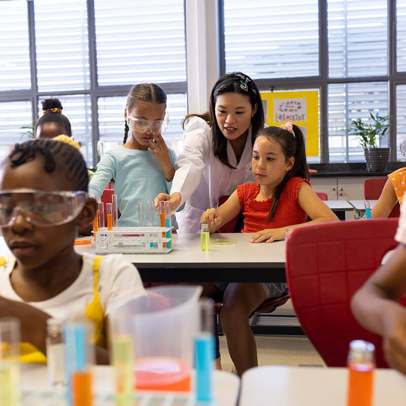 diverse-female-teacher-and-schoolgirls-with-chemis-2024-08-12-17-29-13-utc